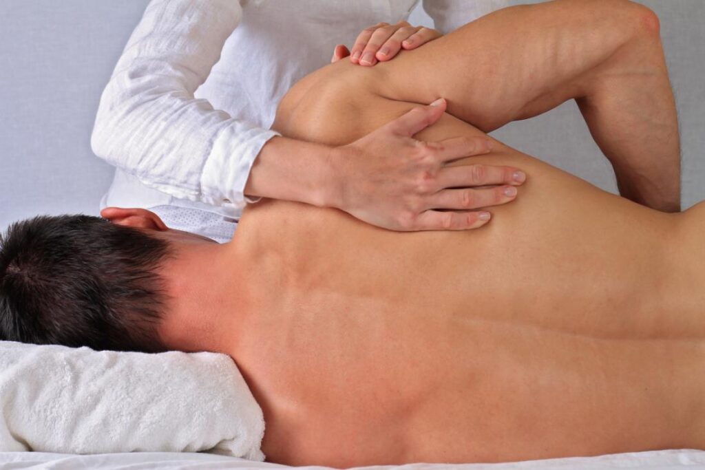 A man laying on his back getting a massage